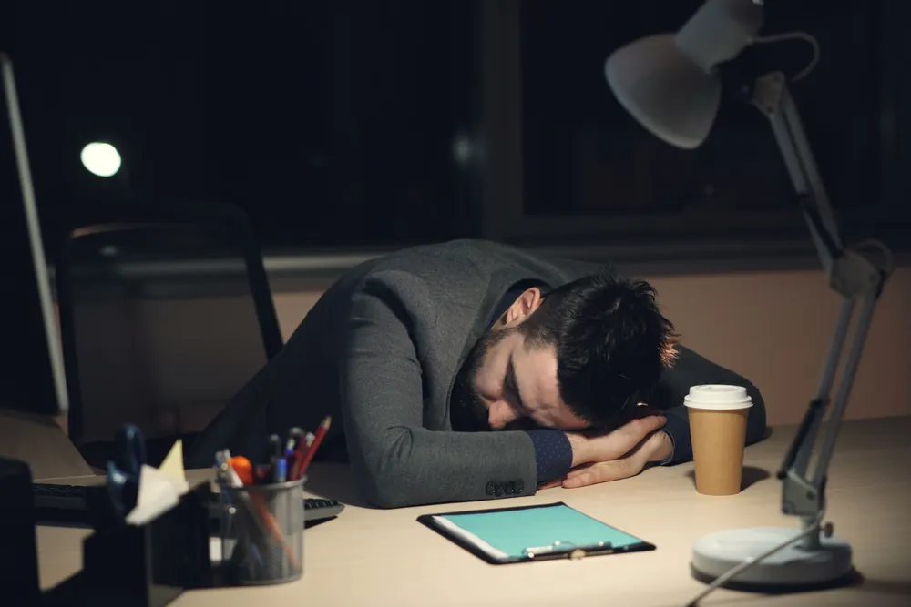 persona agotada en cama sin poder dormir insomnio
